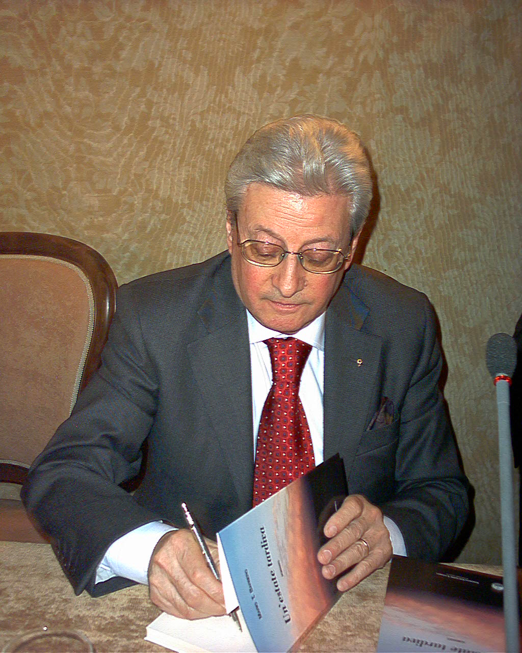 Mario Barbero mentre firma una copia di Un’estate tardiva
